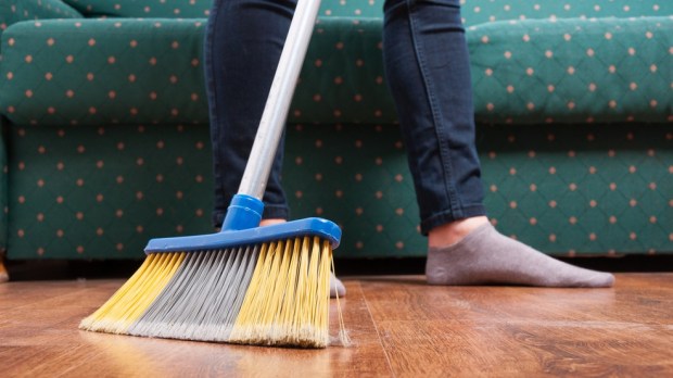 Woman sweeping wooden floor