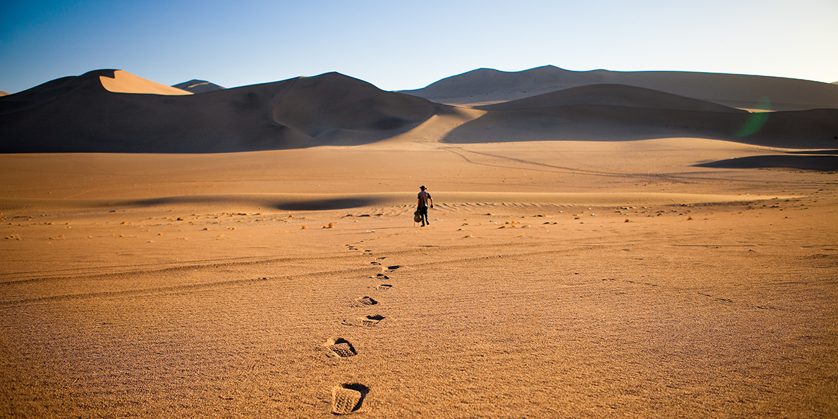 WALKING ALONE IN THE DESERT WITH FOOTSTEPS