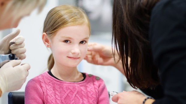 Girl having ear piercing process