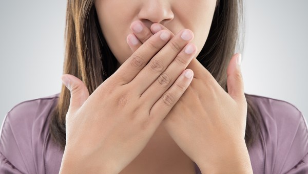 KOBIETA ZAKRYWA USTA