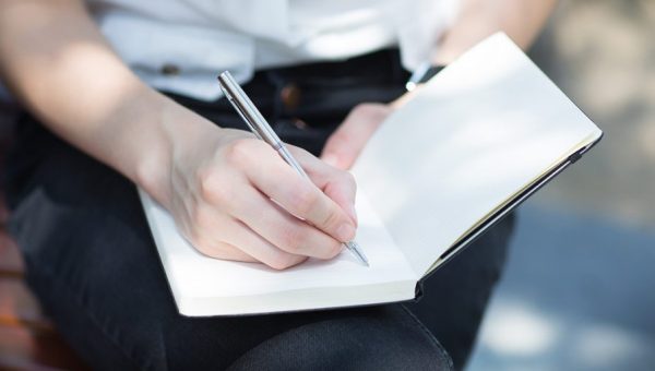 WOMAN WRITING NOTES