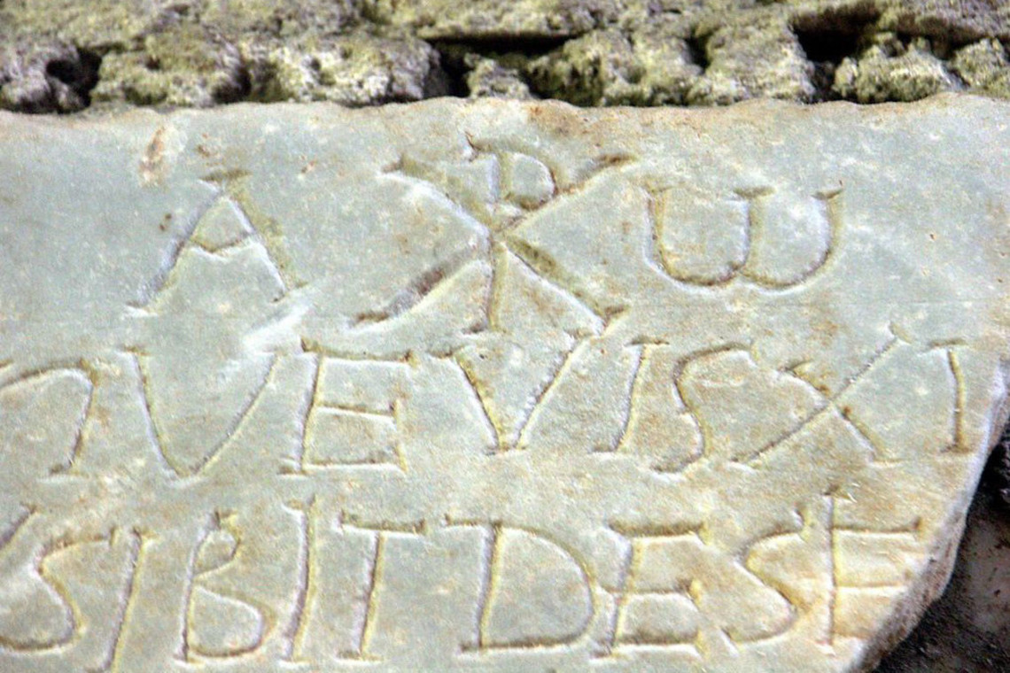 web-catacomb-rome-domitilla-katakomben_steintafel_mit_inschrift_alpha_und_omega_und_christussymbol_chi_rho-dnalor-01-cc1