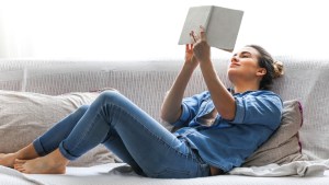 WOMAN, READING, SOFA