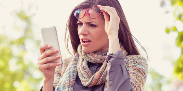 WOMAN LOOKING AT PHONE CONFUSED