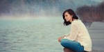 GIRL SITTING BY LAKE