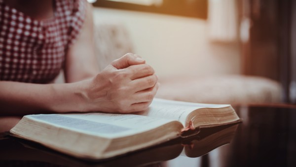 kobieta czyta Biblię siedząc na kanapie