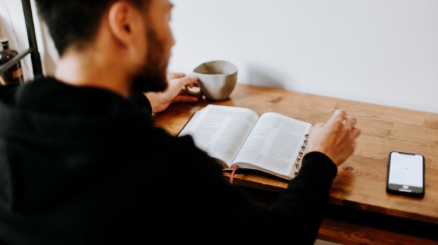 mężczyzna czyta Pismo święte o poranku przy kawie