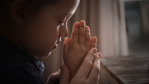 Child praying with mother
