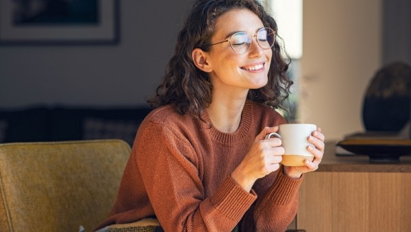 Happy young woman drinking a cup of tea
