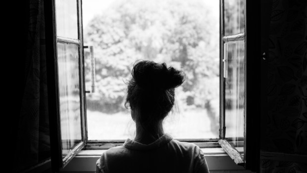 Woman looking through the old window