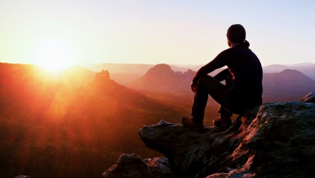 Tourist sits on a cliff
