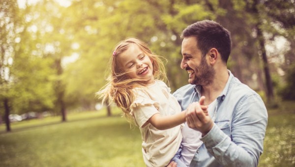 Father and daughter at park dancing and holding hands