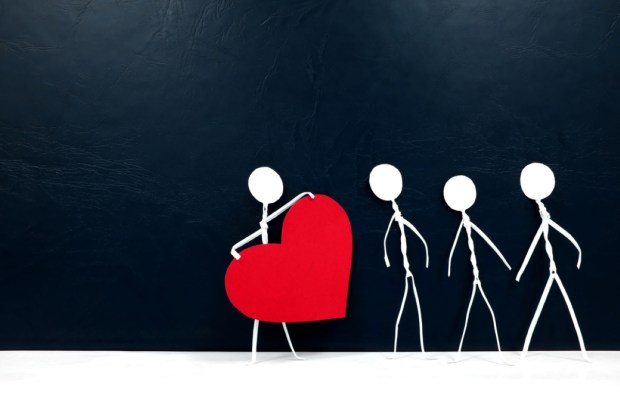 Human stick figure holding a big red heart in dark background