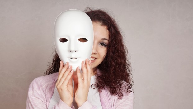 happy girl peeking behind mask