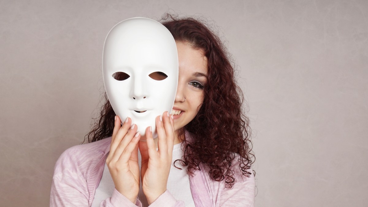 happy girl peeking behind mask