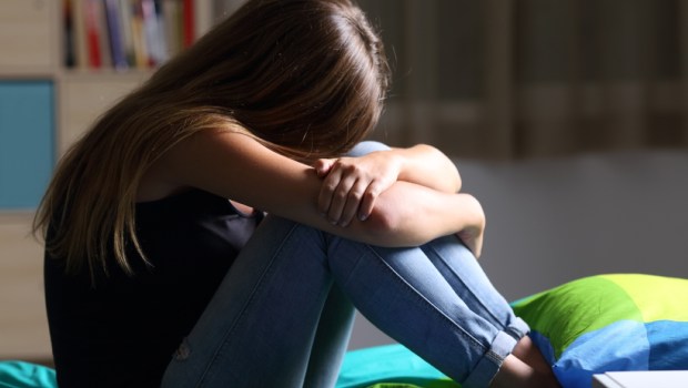 sad teen sitting on the bed