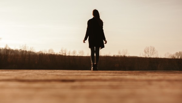 kobieta stoi samotnie na pustej przestrzeni i spogląda na horyzont