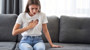 Woman sitting with strong chest pain