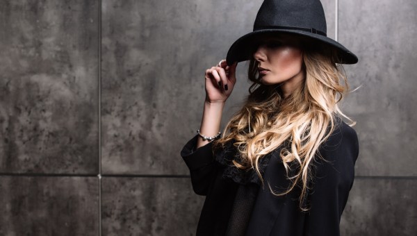 Tajemnicza kobieta zakrywa oczy kapeluszem