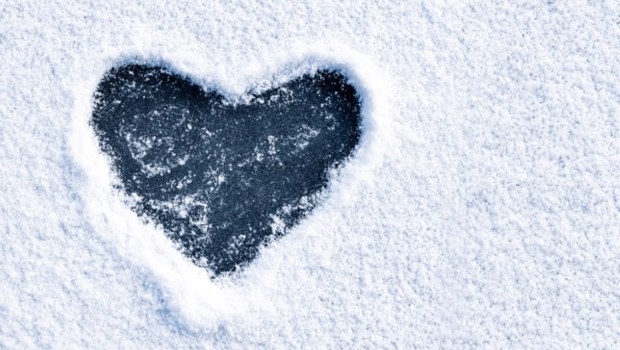 Heart shape love sign, drawn on a snow-covered ice on a winter lake