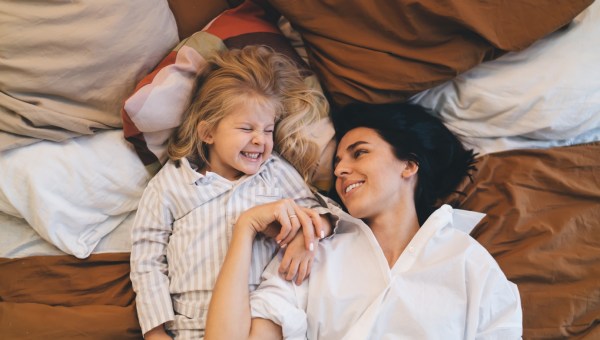 Mama z córką leżą w piżamach na kanapie