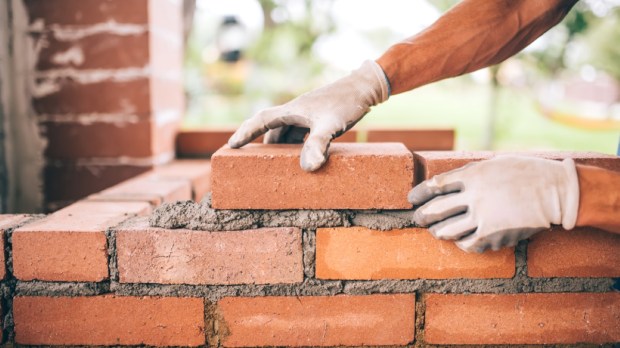 professional construction worker laying bricks