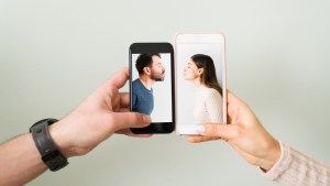 Close up of the hands of an attractive couple with smartphones and the photograph