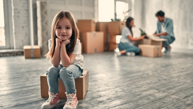 Family on moving day. Couple with their cute little daughter are happy to move into new home