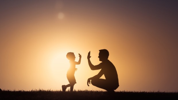 Father giving his son a hight five outdoors in the park