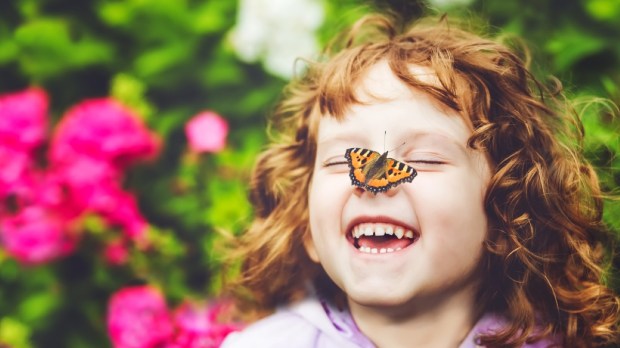 Laughing girl with a butterfly on her nose