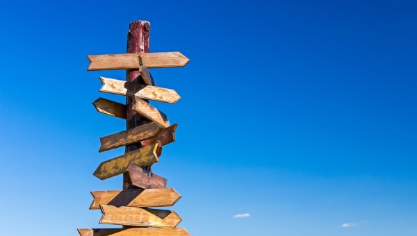 Old wooden road signs with many left and right arrows