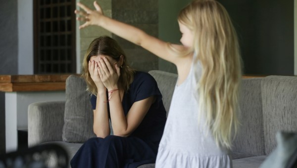 child throwing tantrum at tired mother