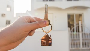 Mão segura a chave de uma casa