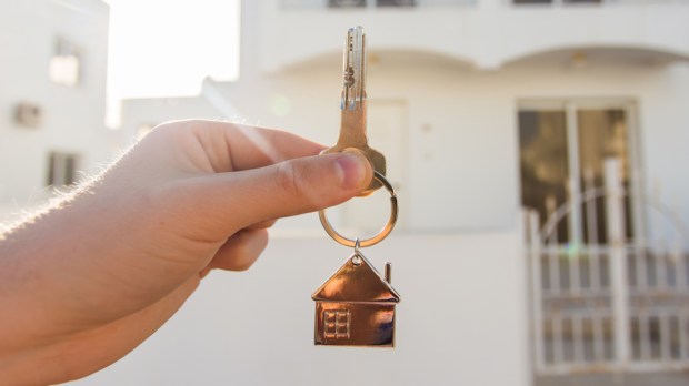 Mão segura a chave de uma casa
