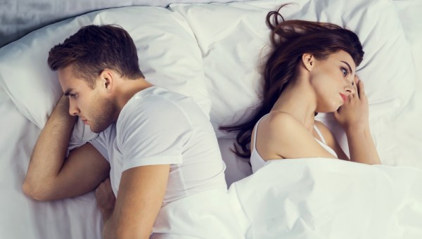 unhappy young couple on the bed in bedroom