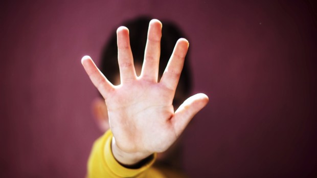 Boy with hand out in rejecting gesture