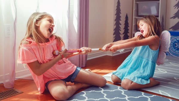 Two little mad angry girls sisters having fight at home