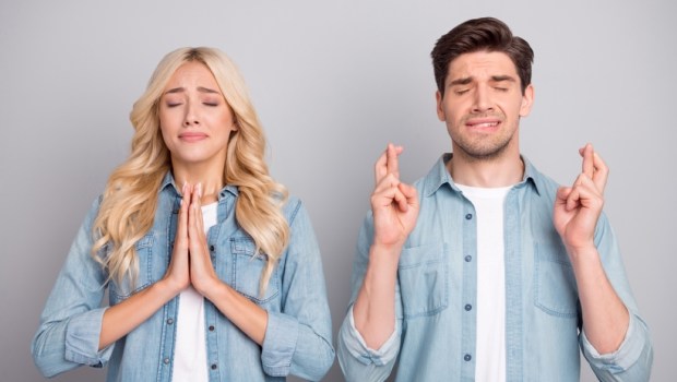 Photo of young couple ask beg wish hope luck success pleading waiting wish isolated over grey color background