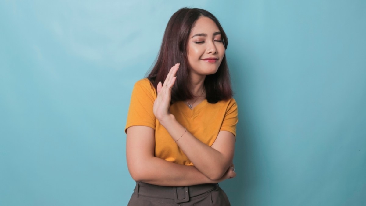 Stop. Concerned Asian woman showing refusal sign, saying no