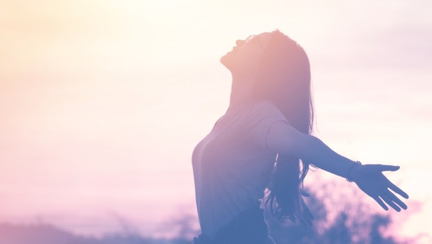 Young woman relaxing in summer sunset sky outdoor