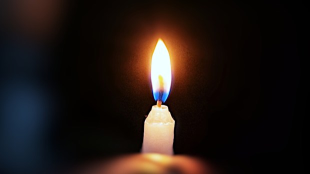 Candle held in hand in the darkness