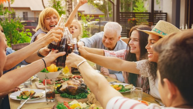 Family and Friends Gathered Together at the Table Raise Glasses and Bottles