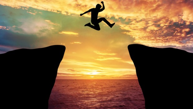 Man jump through the gap between hill.