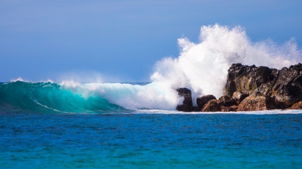 Beautiful waves crashing on rocks in Waimea Bay in the island of Oahu, Hawaii, USA