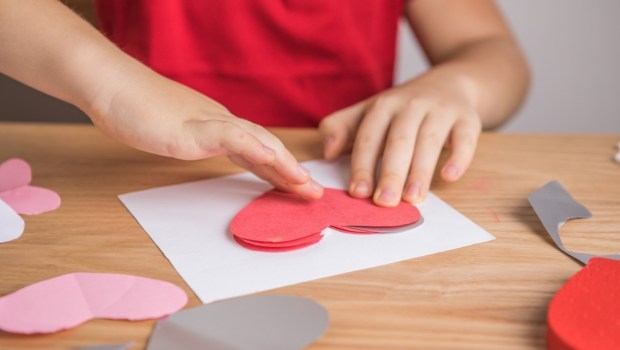 DIY holiday card with red paper heart, symbol of love
