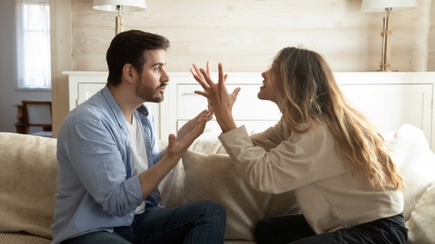 Emotional annoyed stressed couple sitting on couch