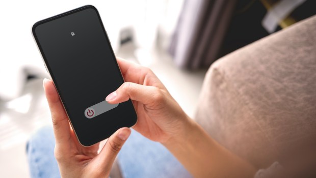 Woman hand using is sliding to turn off the mobile phone