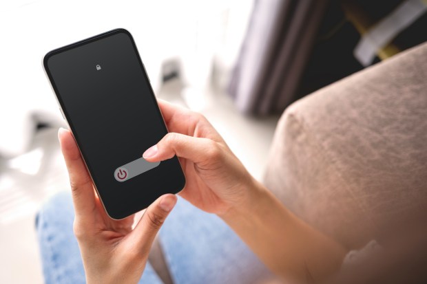 Woman hand using is sliding to turn off the mobile phone