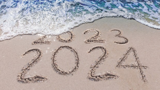 2023 2024 on sand with waves hitting beach