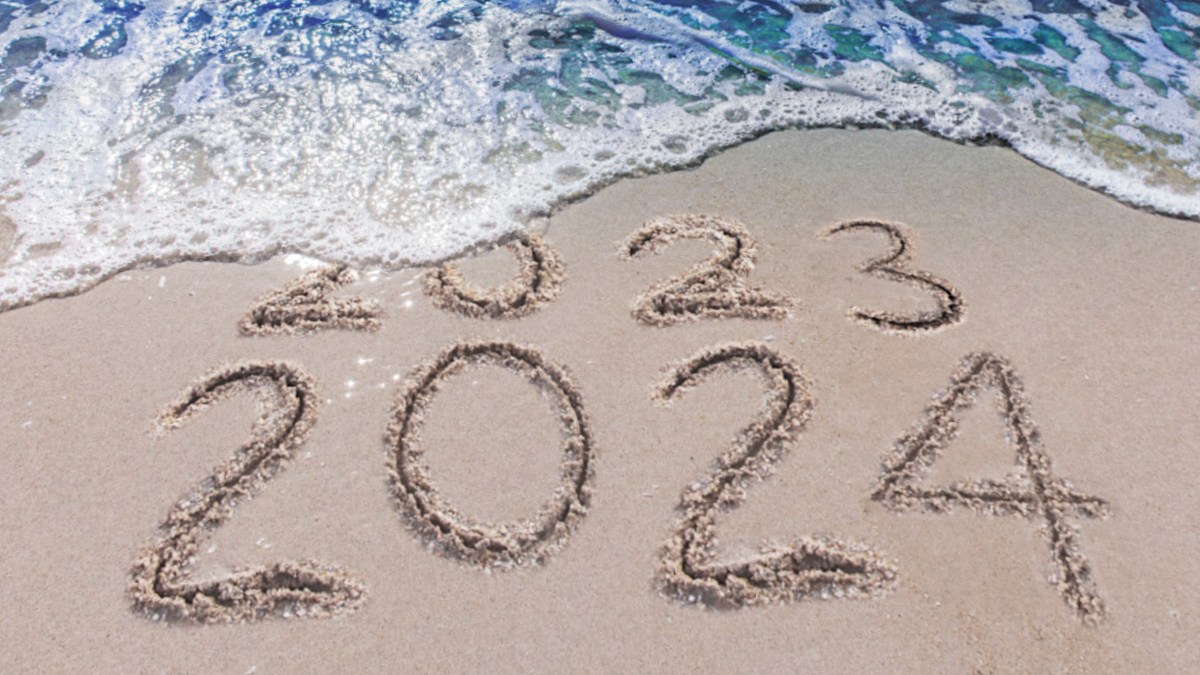 2023 2024 on sand with waves hitting beach